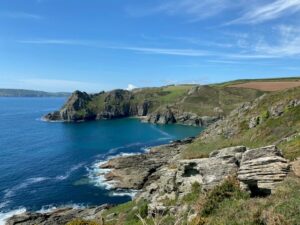 Landscape of rocky grey cliffs and blue sea.