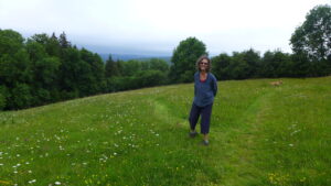 A lady stands in a green wildlife rich meadow