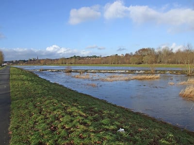 River Exe overflow channel is shown to be full and up to the level of the grassy banks either side of the large body of water.